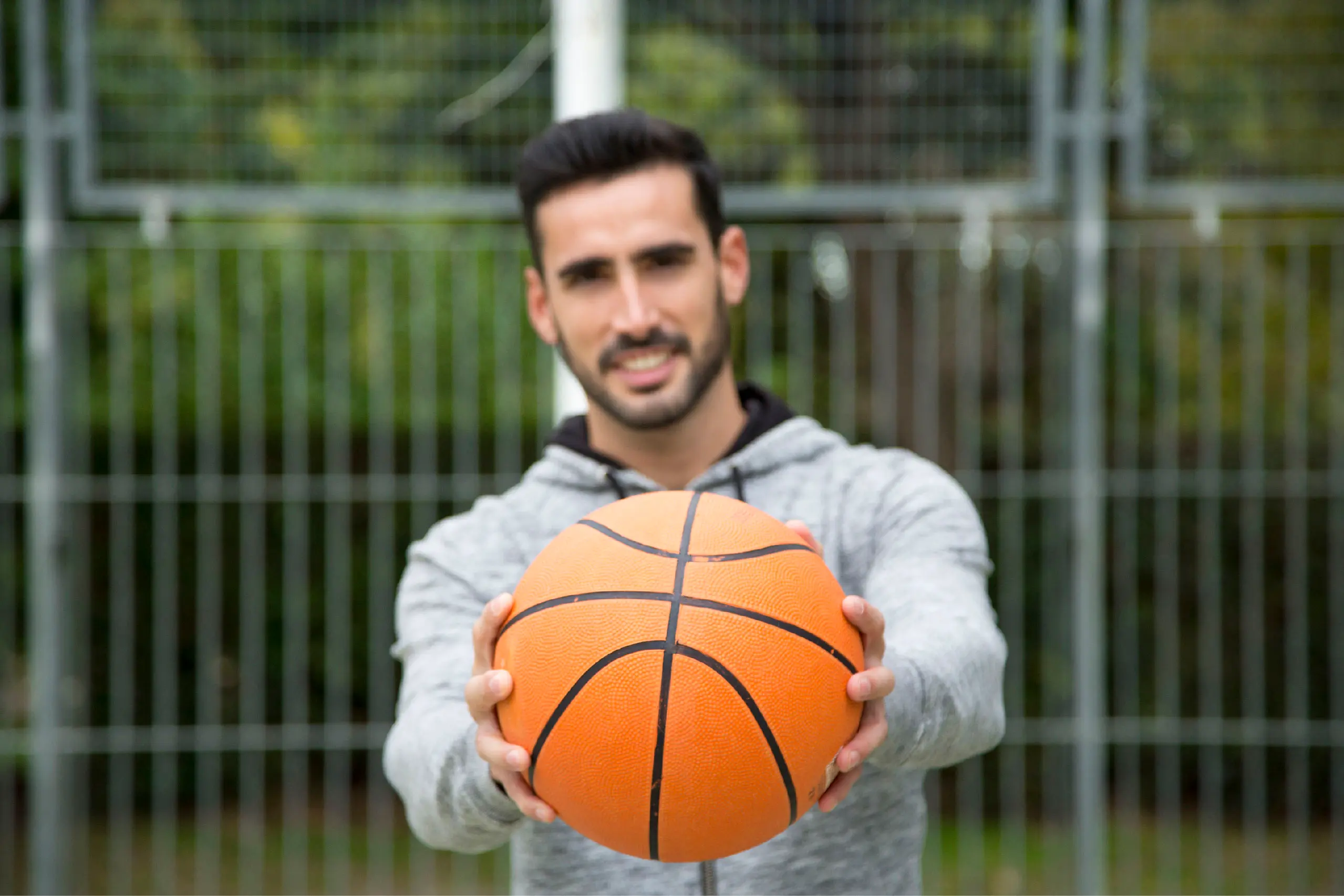 man showing a basketball ball outdoors