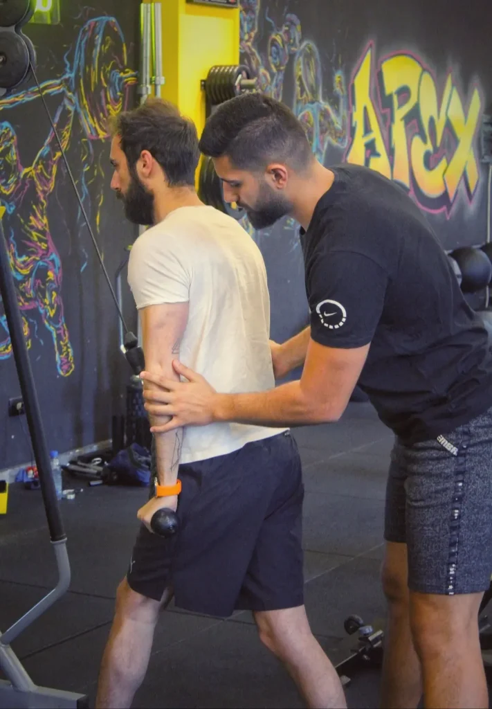 Charbel yazbeck PT training his client on the cables